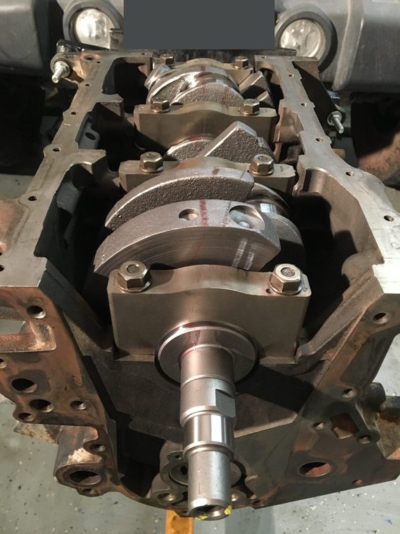 Crankshaft and fitted bearing caps viewed from the open underside of the engine block.