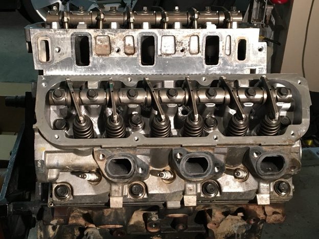 Cylinder heads on the engine with the rocker assemblies and valve springs exposed.